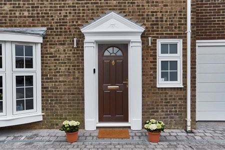 Traditional composite front door finished in Dark Woodgrain from the Anglian doors range
