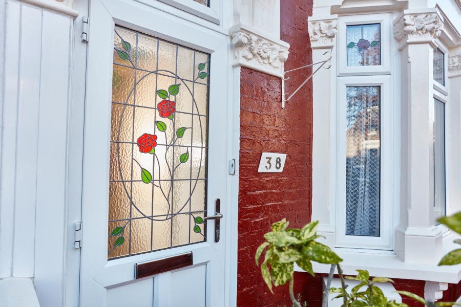 White UPVC front door with decorative glass rose and lead bar pattern from the Anglian UPVC doors range
