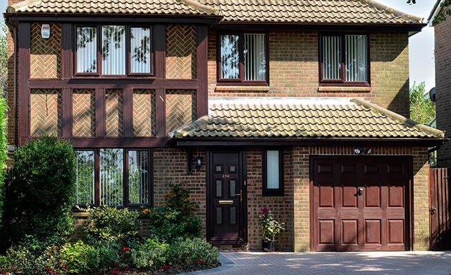 Replacement UPVC double glazed casement windows and doors finished in Dark Woodgrain with new UPVC cladding and guttering