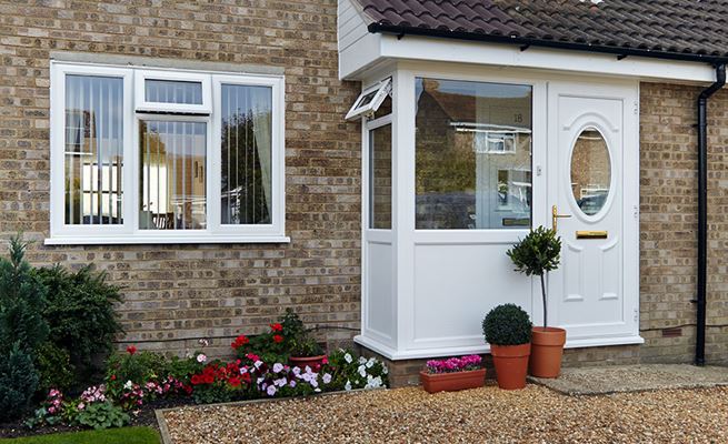 White UPVC casement window on small UPVC porch with traditional front door from the Anglian windows and porches range