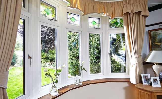 White UPVC bay casement window with decorative bevelled glass and chrome handles from the Anglian double glazing range