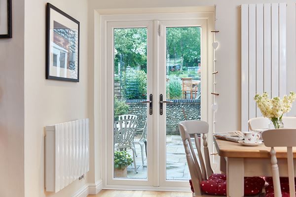 Pair of uPVC French doors in Cream with chrome handles in modern dining room from the Anglian French doors range
