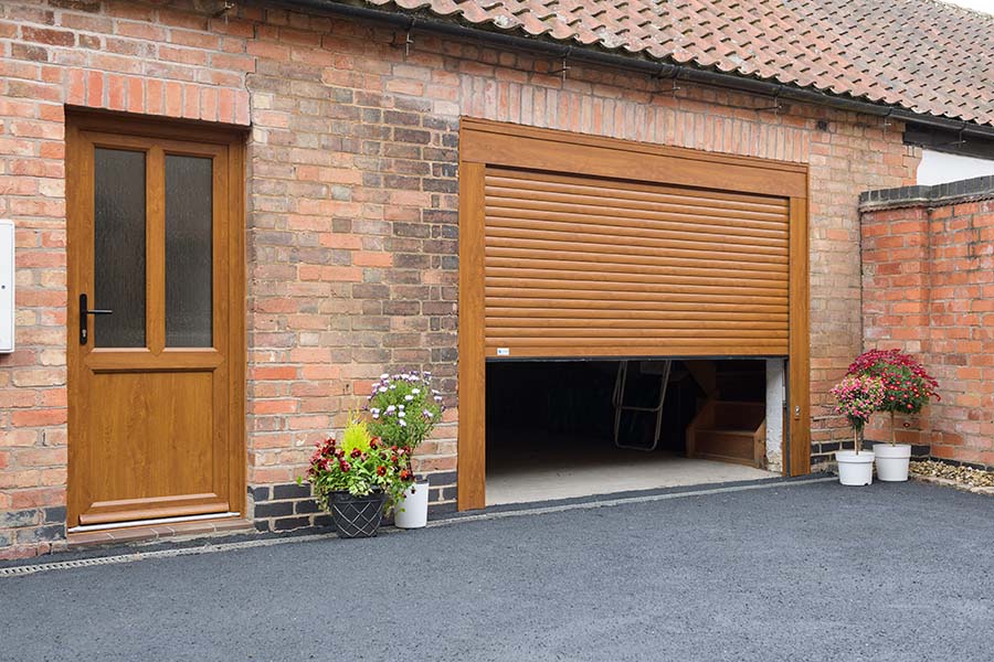 Golden oak aluminium roller garage door with PVCU door