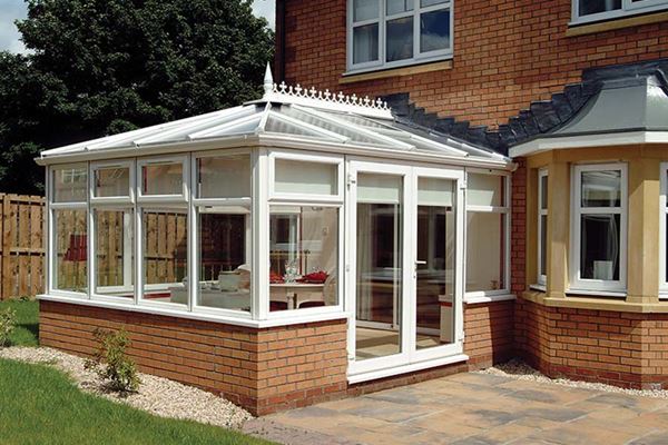 White Knight classic UPVC conservatory with top hung casement windows and French doors finished with traditional finials