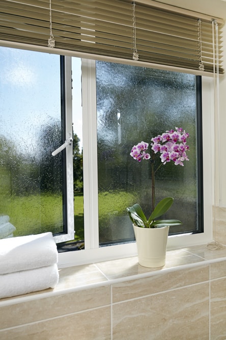 Internal view of White Aluminium casement window with pink orchid on windowsill