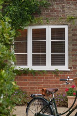 Exterior view of White UPVC casement window with cottage bars and blinds from Anglian Home Improvements