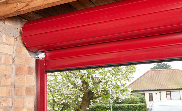 Close up of roller on an electric aluminium roller garage door in red from Anglian Home Improvements