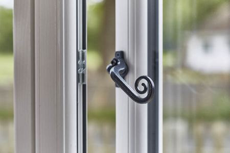 Black monkeytail handle on white flush uPVC casement window from Anglian Home Improvements