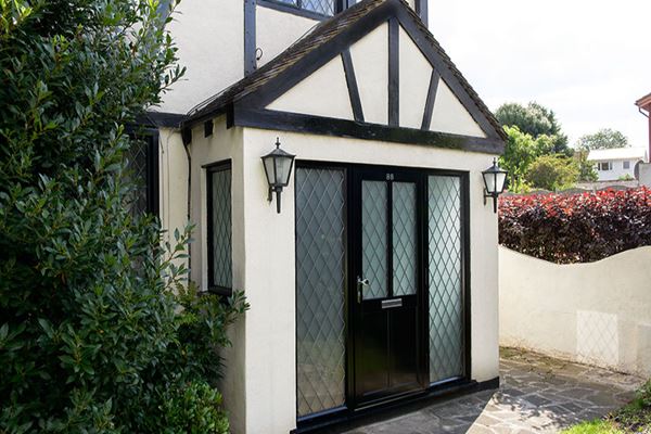 Black aluminium traditional front door with leaded glass and side panels from the Anglian front door range