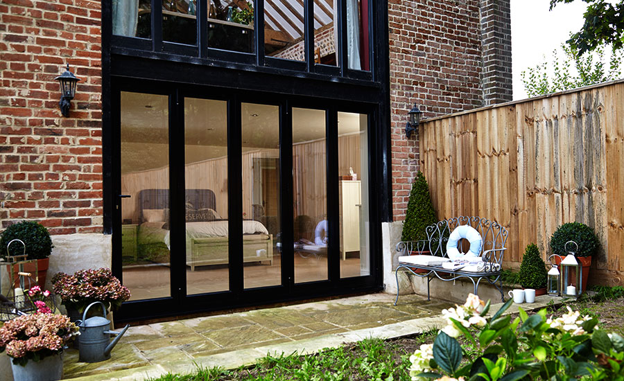 Jet black aluminium bifold doors on ground floor bedroom from the Anglian aluminium bifold door range