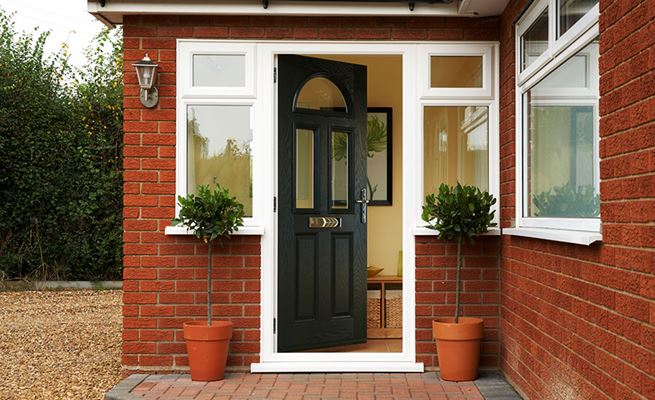 Black traditional composite front door with clear glass and side upvc casement windows from the Anglian composite door range