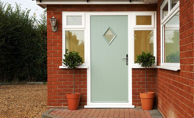 Sage Green composite front door in cottage style with diamond shaped window and chrome handle from the Anglian composite doors range