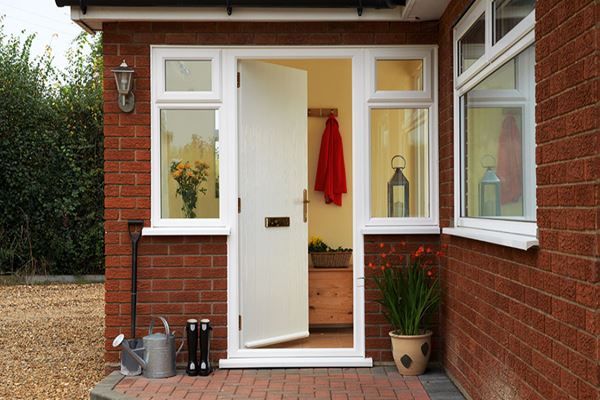 White cottage composite front door with gold handle and letterplate and side casement windows from the Anglian windows and doors range