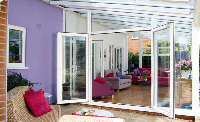 White UPVC contemporary gable end Veranda conservatory with French doors opening onto veranda space from Anglian Home Improvements