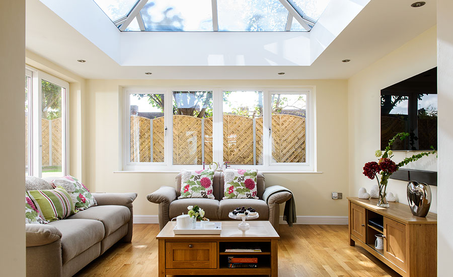 Inside orangery living room extension with square roof lantern and white UPVC casement windows from Anglian Home Improvements