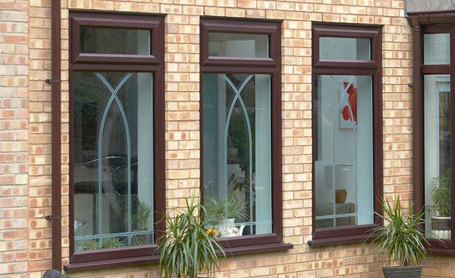UPVC casement windows finished in dual Dark Woodgrain and White with etched decorative glass from Anglian Home Improvements