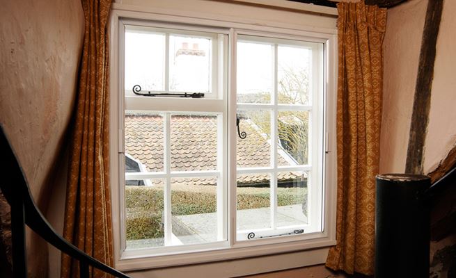 White secondary glazed window with black monkeytail handles on period property from Anglian Home Improvements