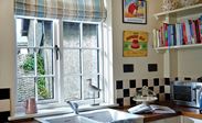 White wooden double glazed kitchen window with Georgian bars and black window handle from the Anglian timber window range
