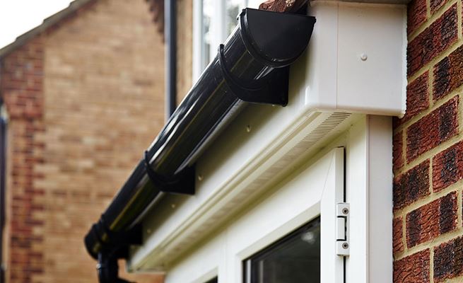 Black uPVC guttering in contrasting colour to soffits and fascias behind in White from Anglian Home Improvements