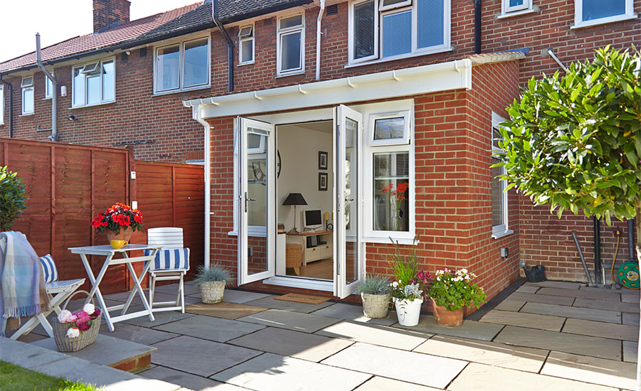 Small red brick extension with UPVC White Knight casement windows and French doors opening onto patio