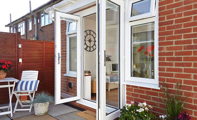 Pair of white uPVC French doors with chrome handles and hinges opening on modern patio
