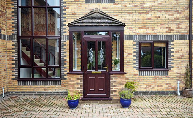 Dark brown woodgrain uPVC front door and brick porch with uPVC casement windows from the Anglian porches range