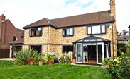 Dual dark brown and white UPVC casement windows patio doors and conservatory with French doors and tilt and turn windows