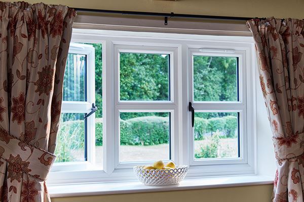 Interior view of traditional white UPVC casement windows with cottage bars and black handles from Anglian Home Improvements