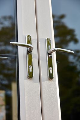 Close up of chrome door handles on white woodgrain uPVC French doors from the Anglian French doors range