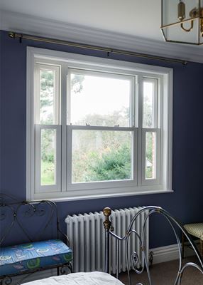 Large white UPVC sash window in bedroom from the Anglian sliding sash window range