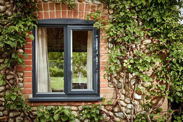 Single Anthracite Grey UPVC double glazed casement window on traditional cobblestone home from the Anglian casement windows range