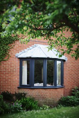 Garden view of Dual Anthracite Grey and White double glazed UPVC bay window from Anglian Home Improvements