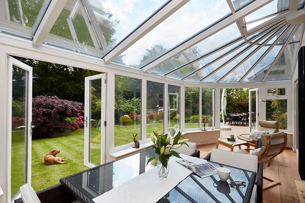 White UPVC lean to Victorian conservatory with French doors opening onto garden from the Anglian classic conservatories range
