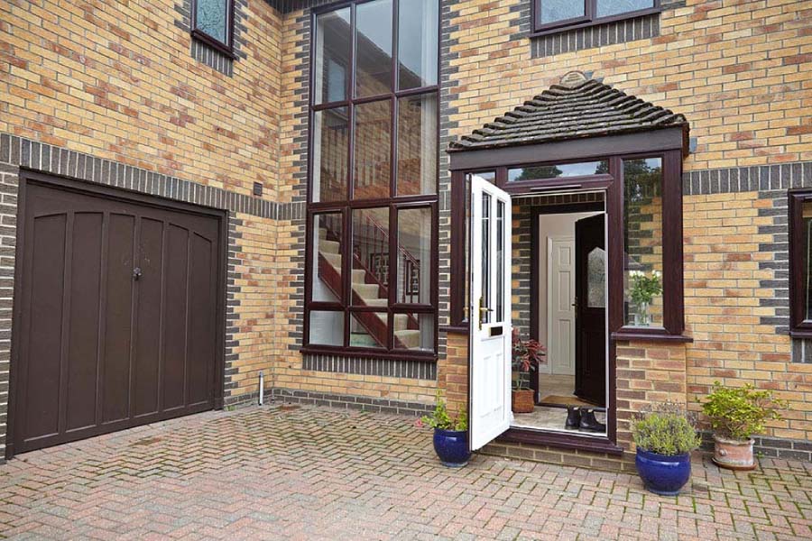 Dual Dark woodgrain and White UPVC porch opening into entrance hall from Anglian Home Improvements