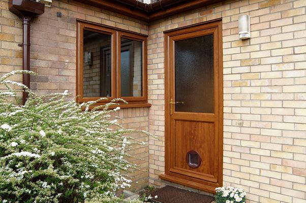 UPVC back door with obscure glass finished in Golden Oak with catflap and matching casement windows