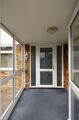 Pair of half glazed white UPVC front porch doors with gold door handles from Anglian Home Improvements