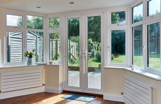 White UPVC triple glazed casement windows and French doors with matching white handles from the Anglian windows and doors range