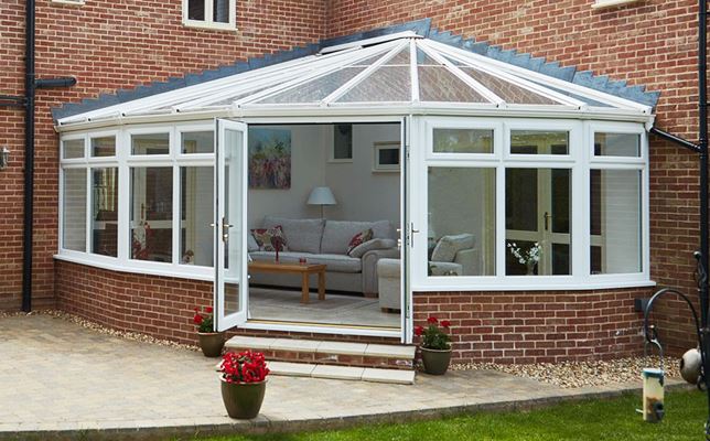 Large UPVC Victorian corner conservatory finished in White Woodgrain with French doors and from the Anglian classic conservatory range
