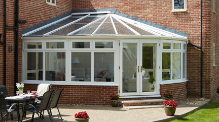 UPVC Victorian corner conservatory finished in white on contemporary home from the Anglian classic conservatory range