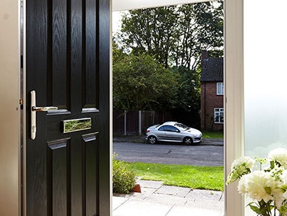Traditional black composite front door open Anglian Home Improvements