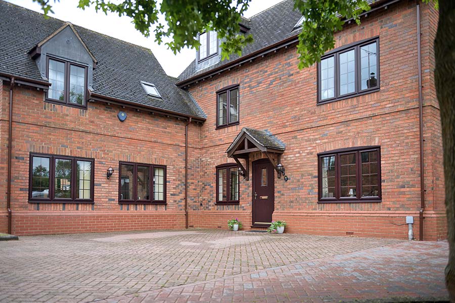 Dark woodgrain Madrid composite door with dark woodgrain casement windows