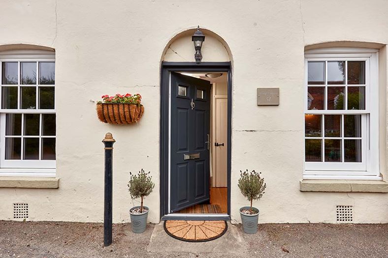 Dual anthracite grey composite door with uPVC sliding sash windows with cottage bars