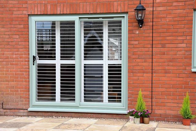 Sage green uPVC sliding patio door with horizontal bar