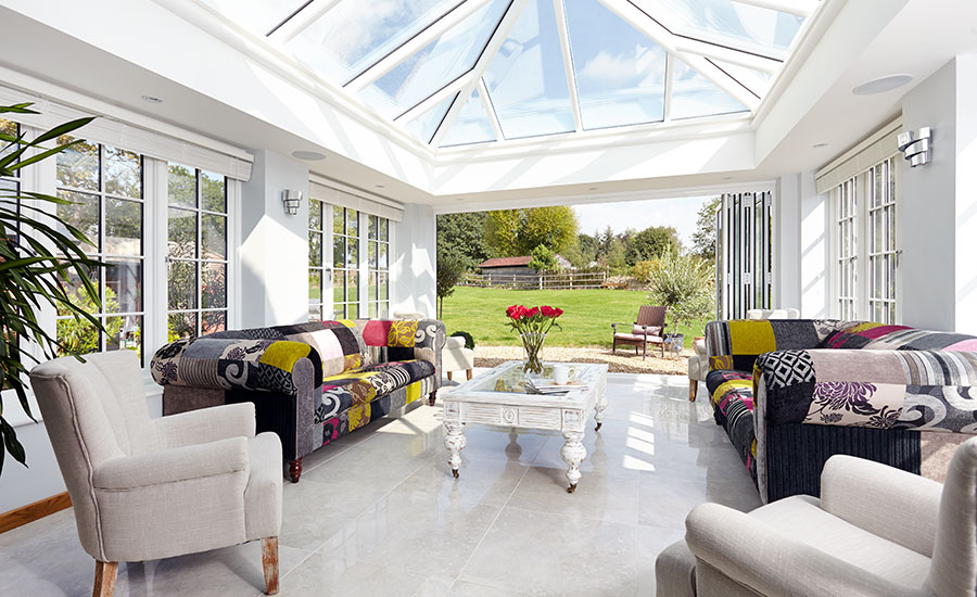 Contemporary white orangery with roof lantern five panel aluminium bi-fold doors and timber casement windows with cottage bars