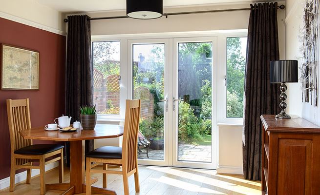 White uPVC French doors with opening side casement windows finished with chrome handles from the Anglian uPVC French doors range