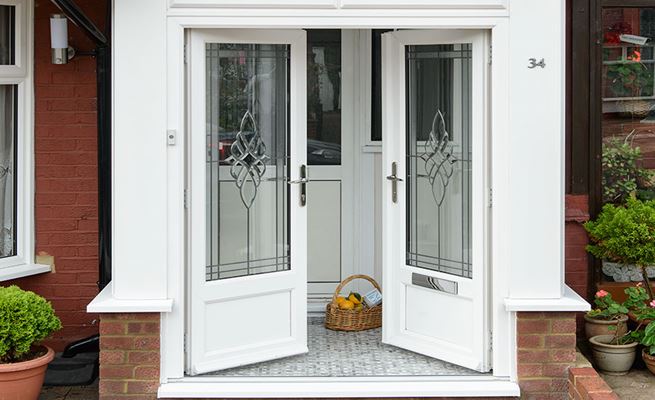 White uPVC double French doors on uPVC front porch with glazed bevelled glass and chrome handles from the Anglian French doors range