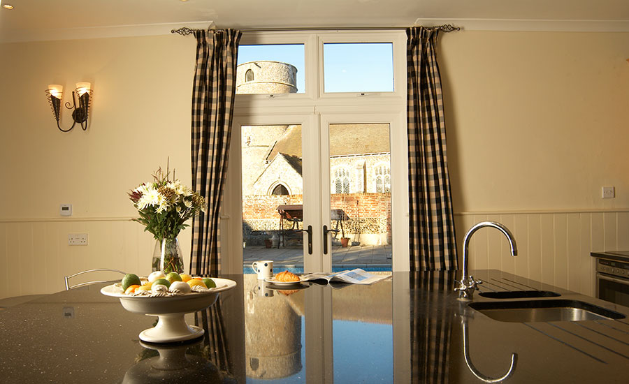 White uPVC French doors with uPVC casement windows above in kitchen with large modern kitchen island