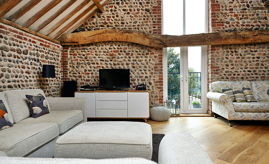 Pair of closed White uPVC French doors with white door handles balcony interior view barn conversion with wooden beams