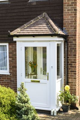 White uPVC porch with tiled roof and uPVC front door half glazed clear glass and gold handle from the Anglian porch range