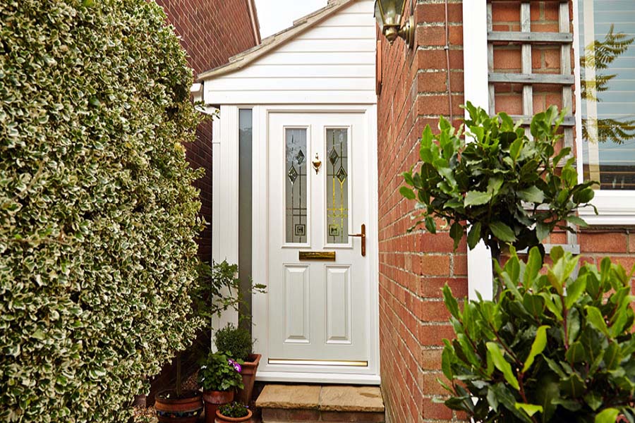 White UPVC front door porch on side of home with decorative etched glass from the Anglian porches range